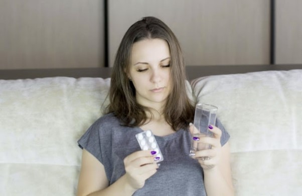 Women sitting on sofa holding tablets, having found out what aciclovir is